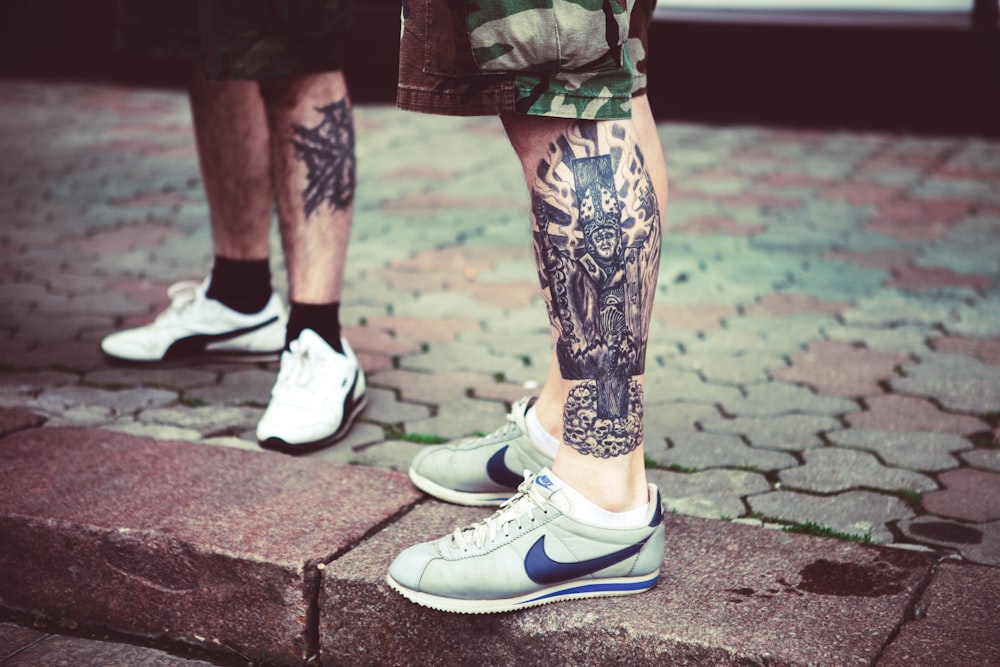 a couple of people with tattoos on their legs