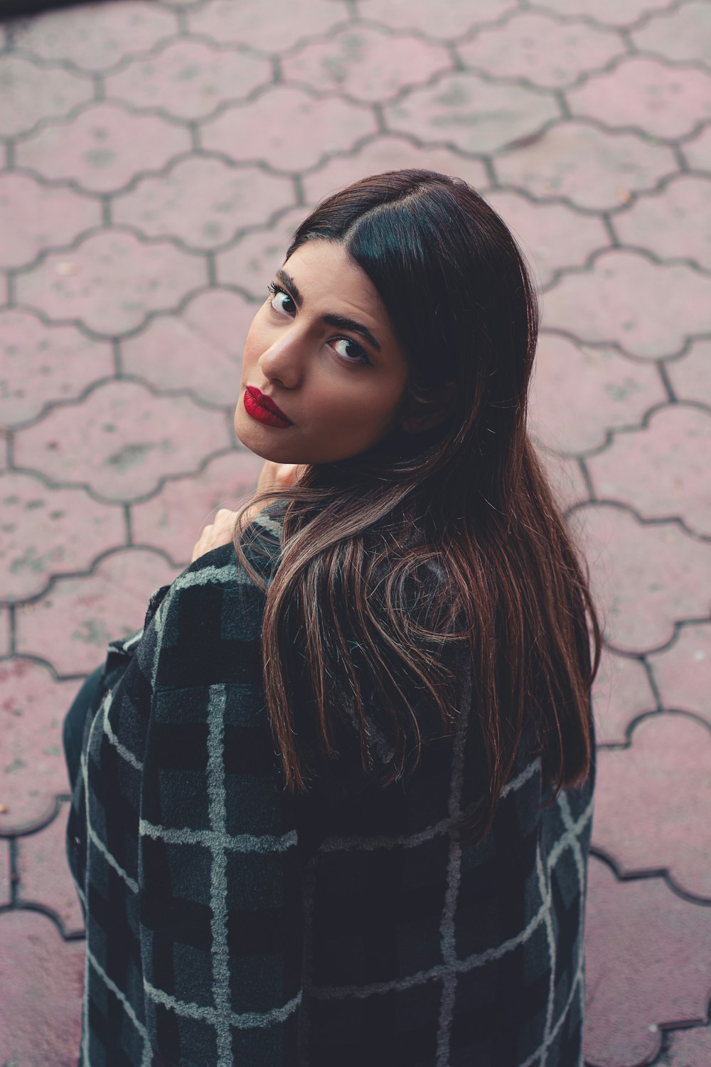 a woman with long hair and a black and white checkered coat