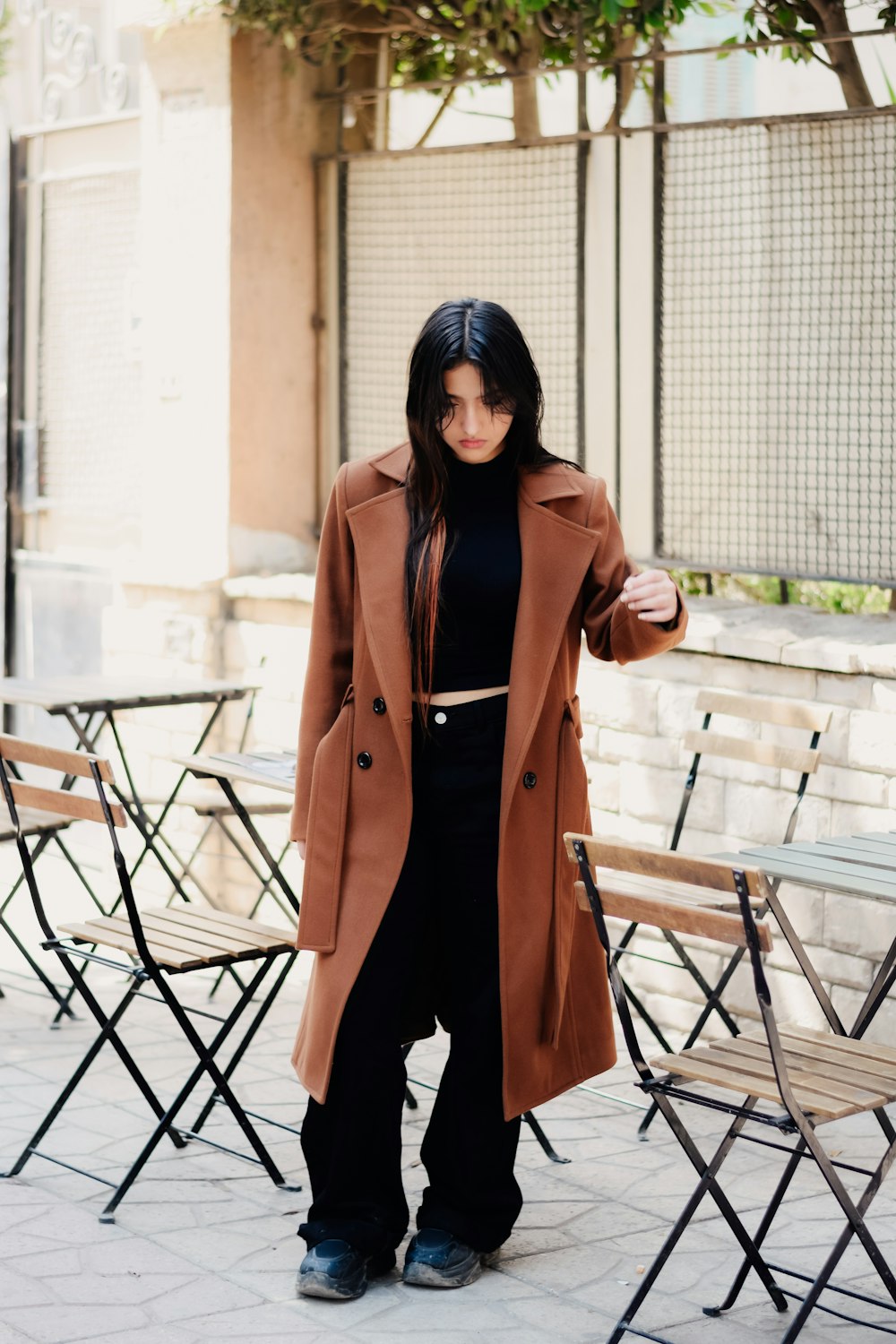 a woman standing in front of a table with chairs