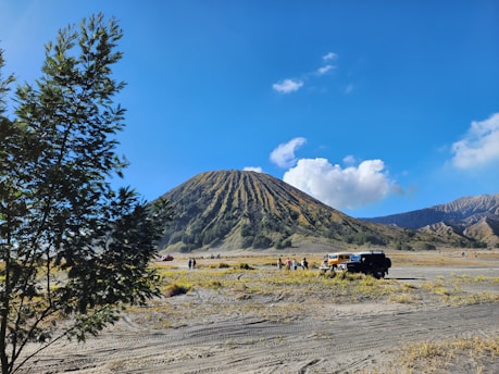 a group of people standing next to a mountain