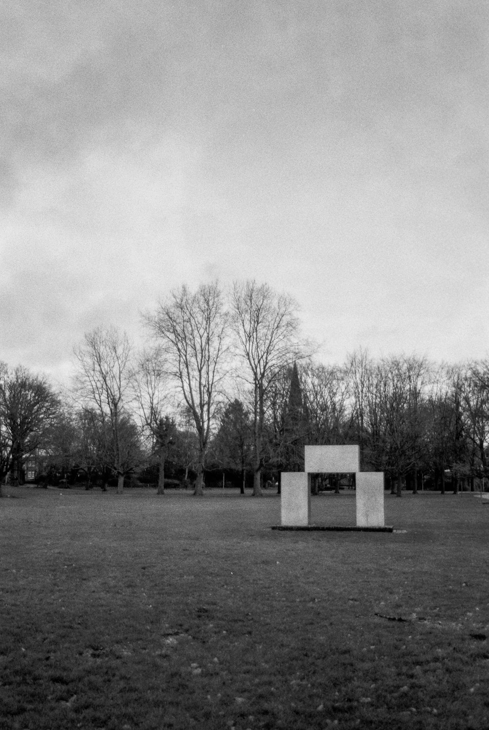 a black and white photo of a bench in a park