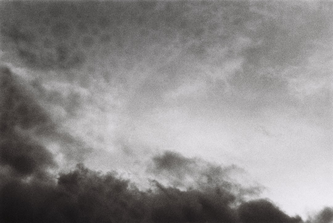 a black and white photo of a plane in the sky,