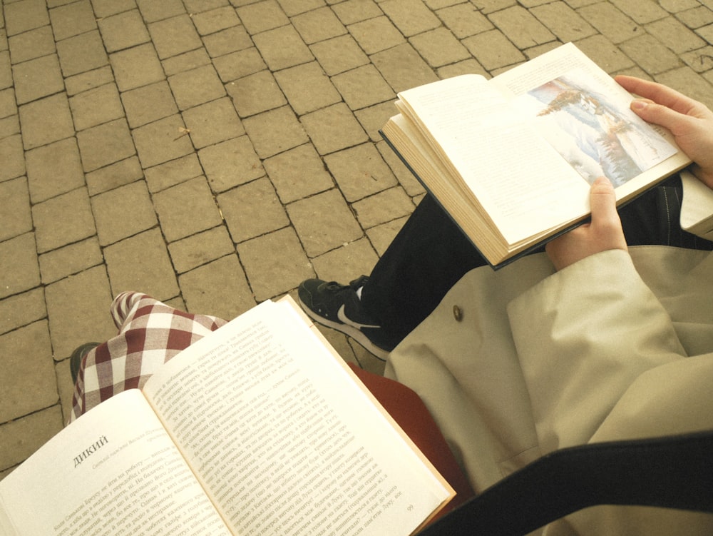 a person sitting on the ground reading a book