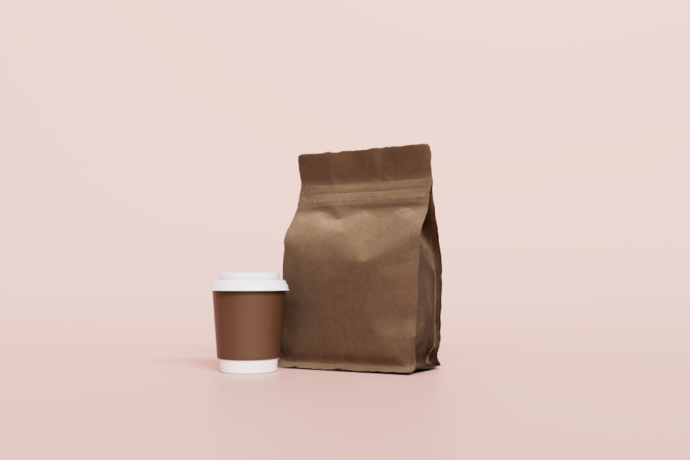 un sachet de café et une tasse de café sur fond rose