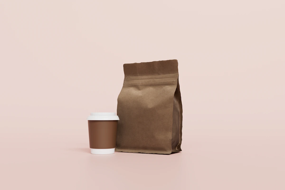 Kraft coffee bag and takeaway cup on a soft pink backdrop