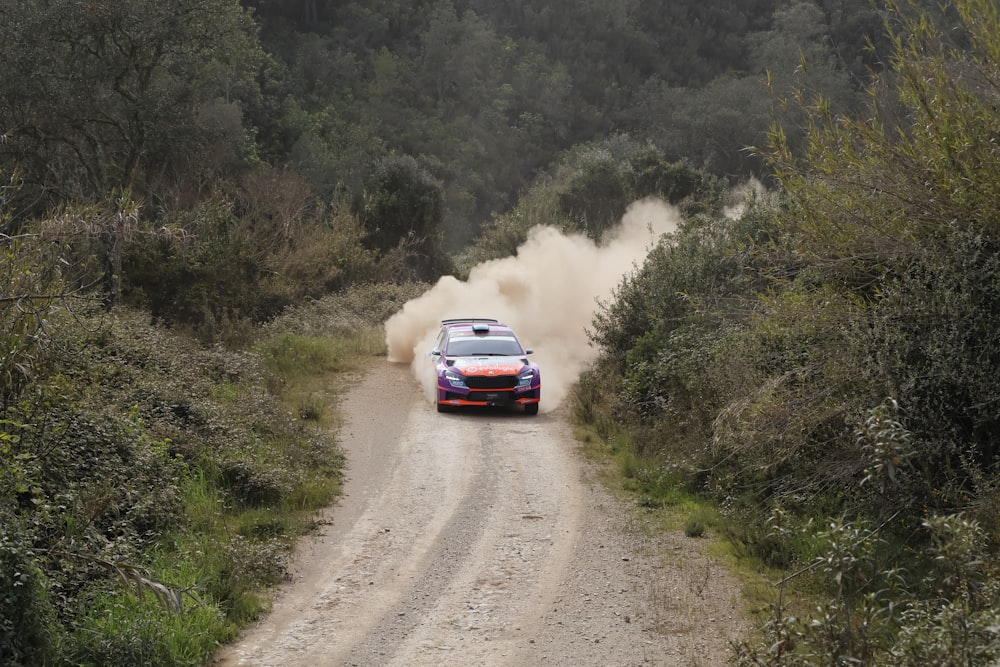 a car is driving down a dirt road