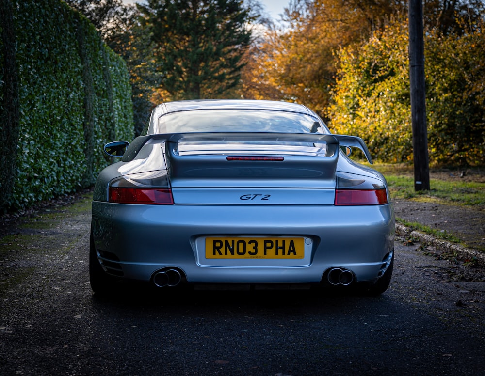 a silver sports car parked on the side of the road