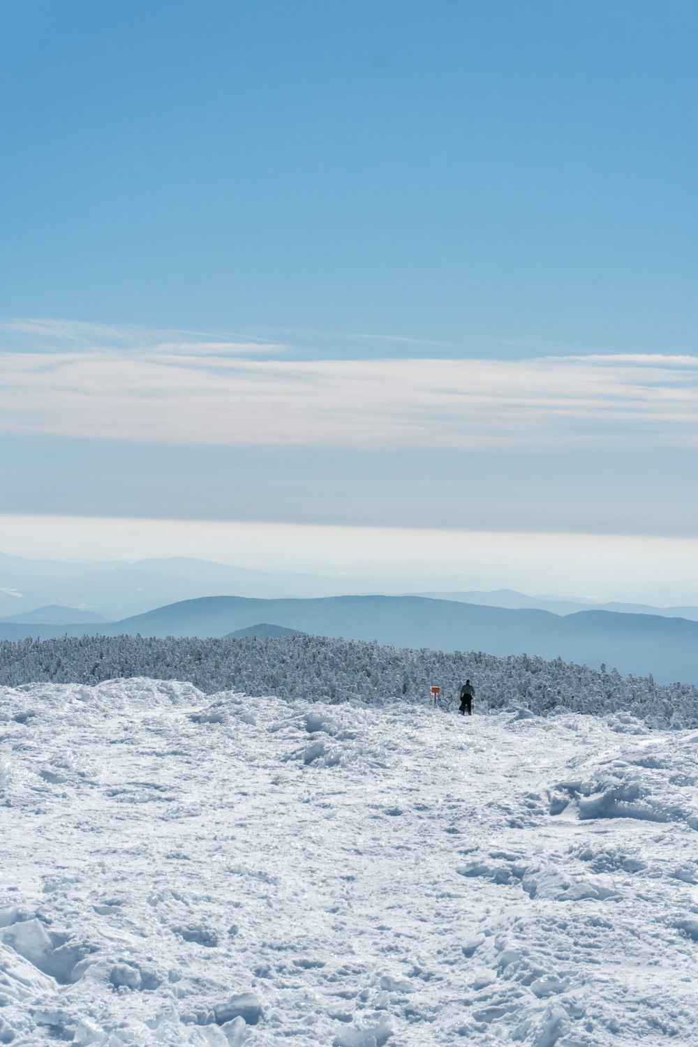 a couple of people standing on top of a snow covered slope