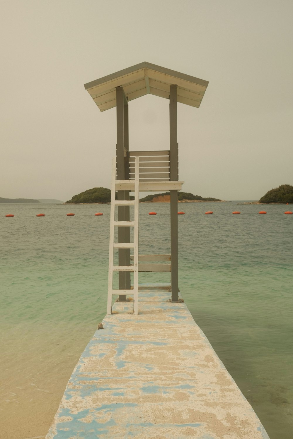 a lifeguard tower sitting on the end of a pier