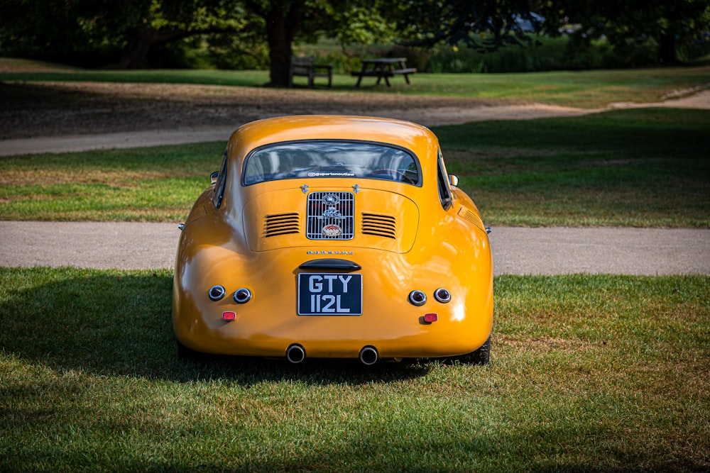 a yellow car is parked in the grass