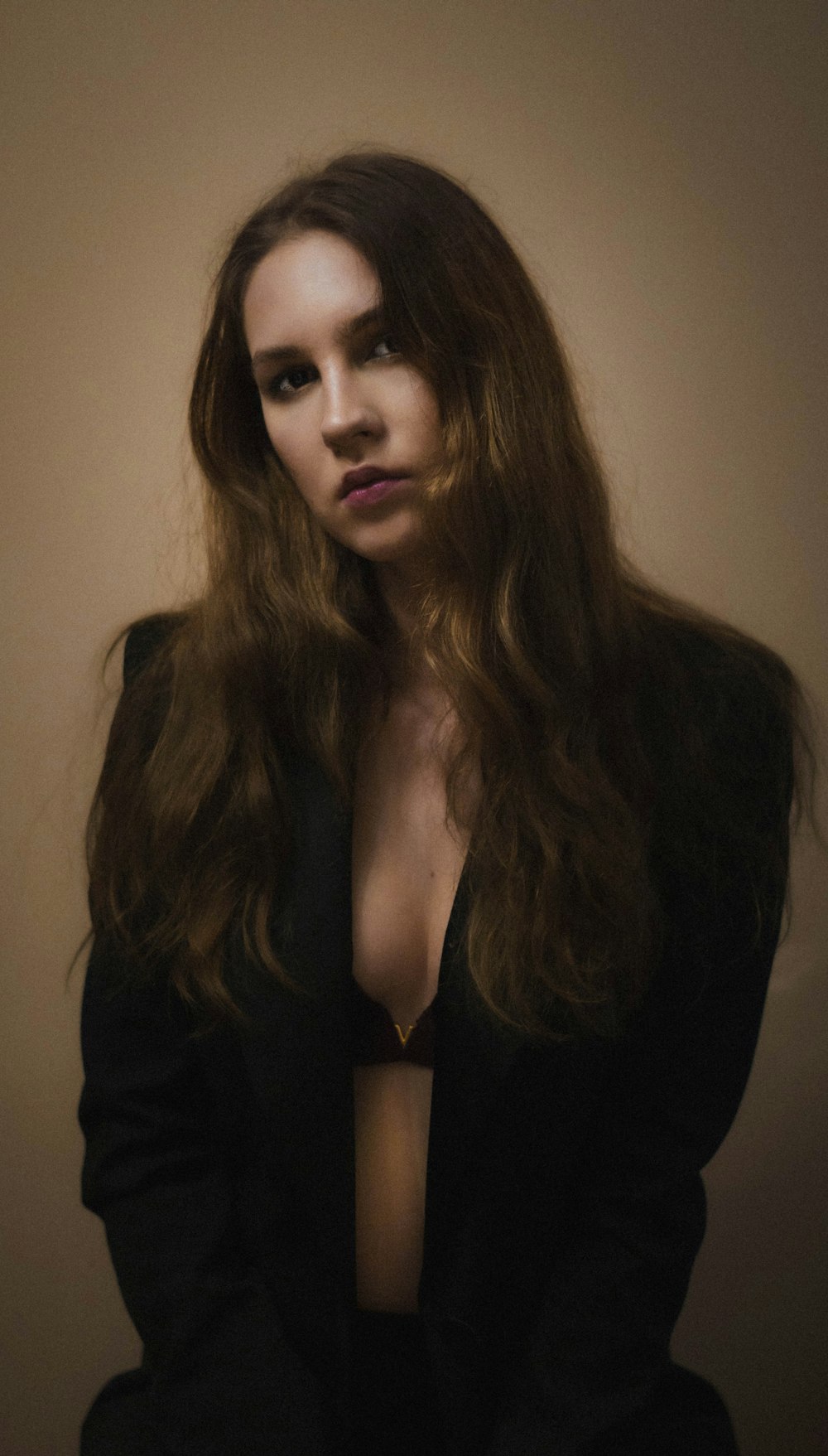 a woman with long brown hair wearing a black suit