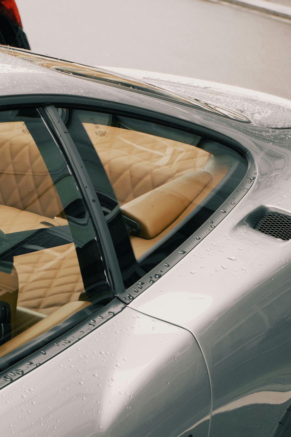 a silver sports car with tan leather seats