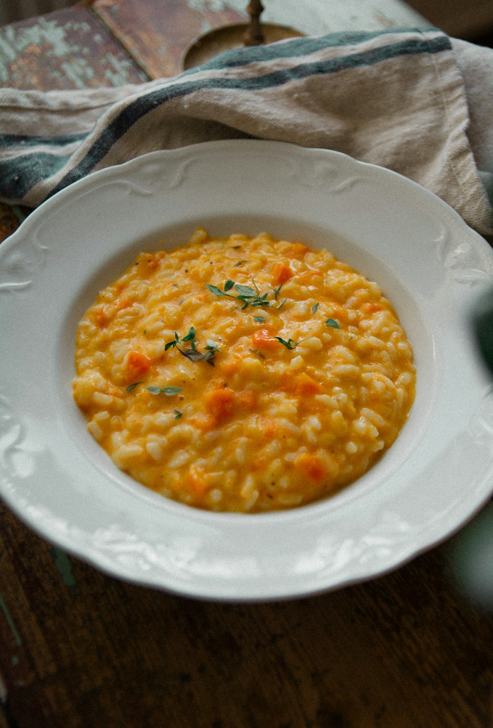 a white plate topped with a bowl of macaroni and cheese