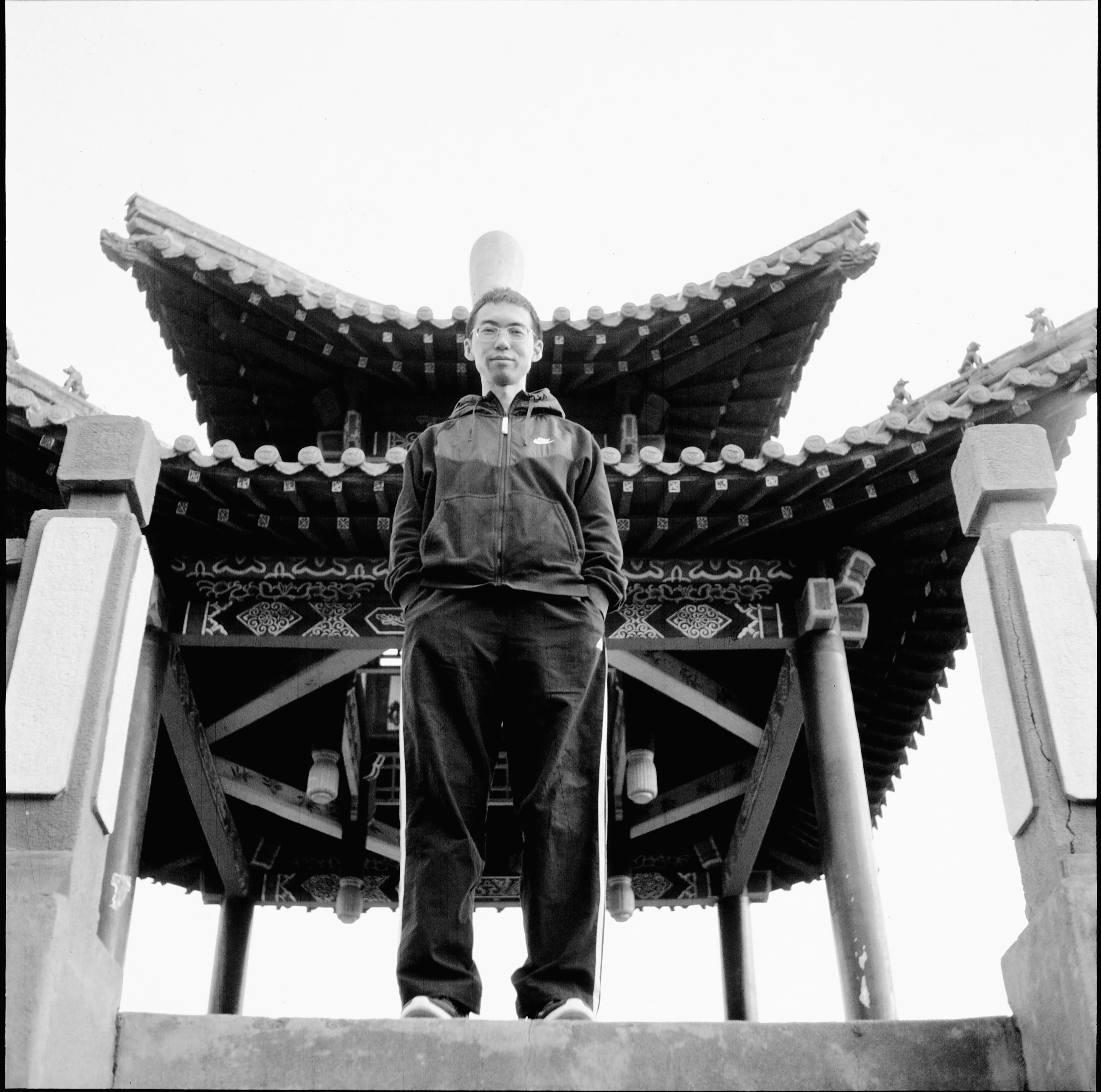 a black and white photo of a man standing in front of a building