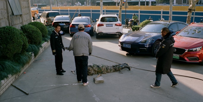 a group of men standing next to each other in a parking lot