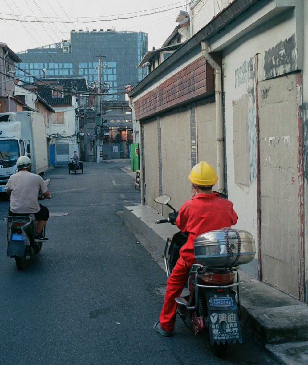 a man riding a motorcycle down a street next to a building