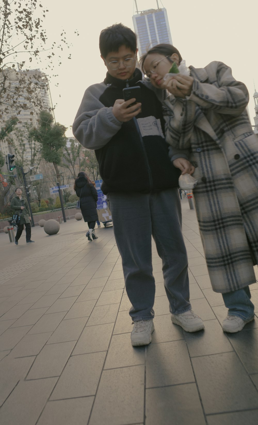 a couple of kids standing next to each other on a sidewalk