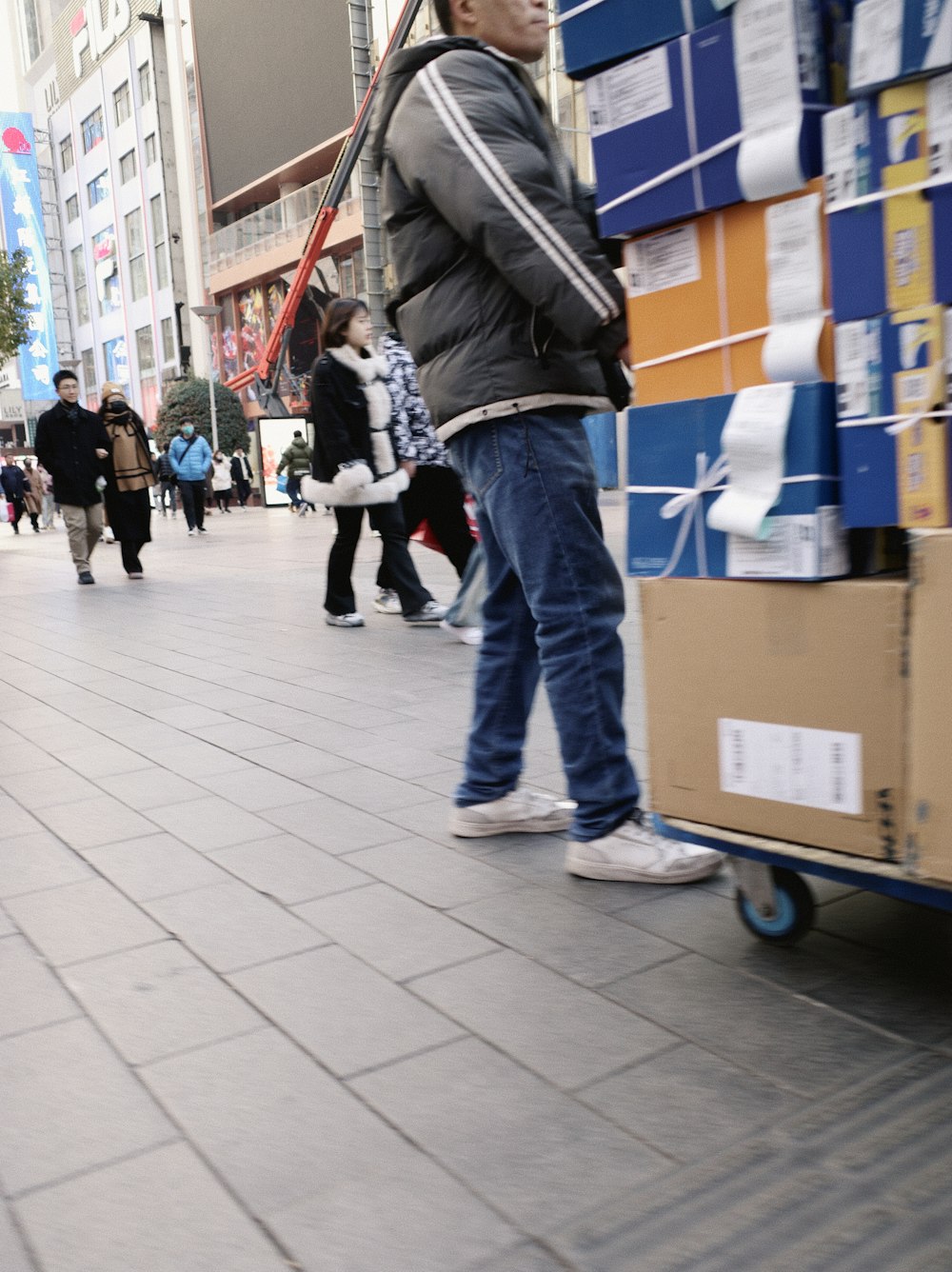 a man with a baseball bat standing next to a cart of boxes