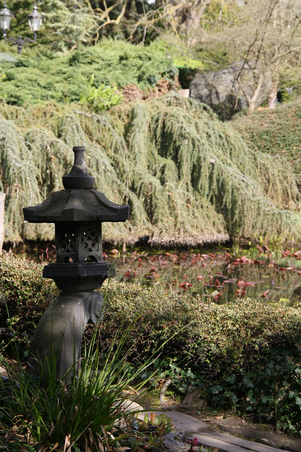 a black lantern in the middle of a garden