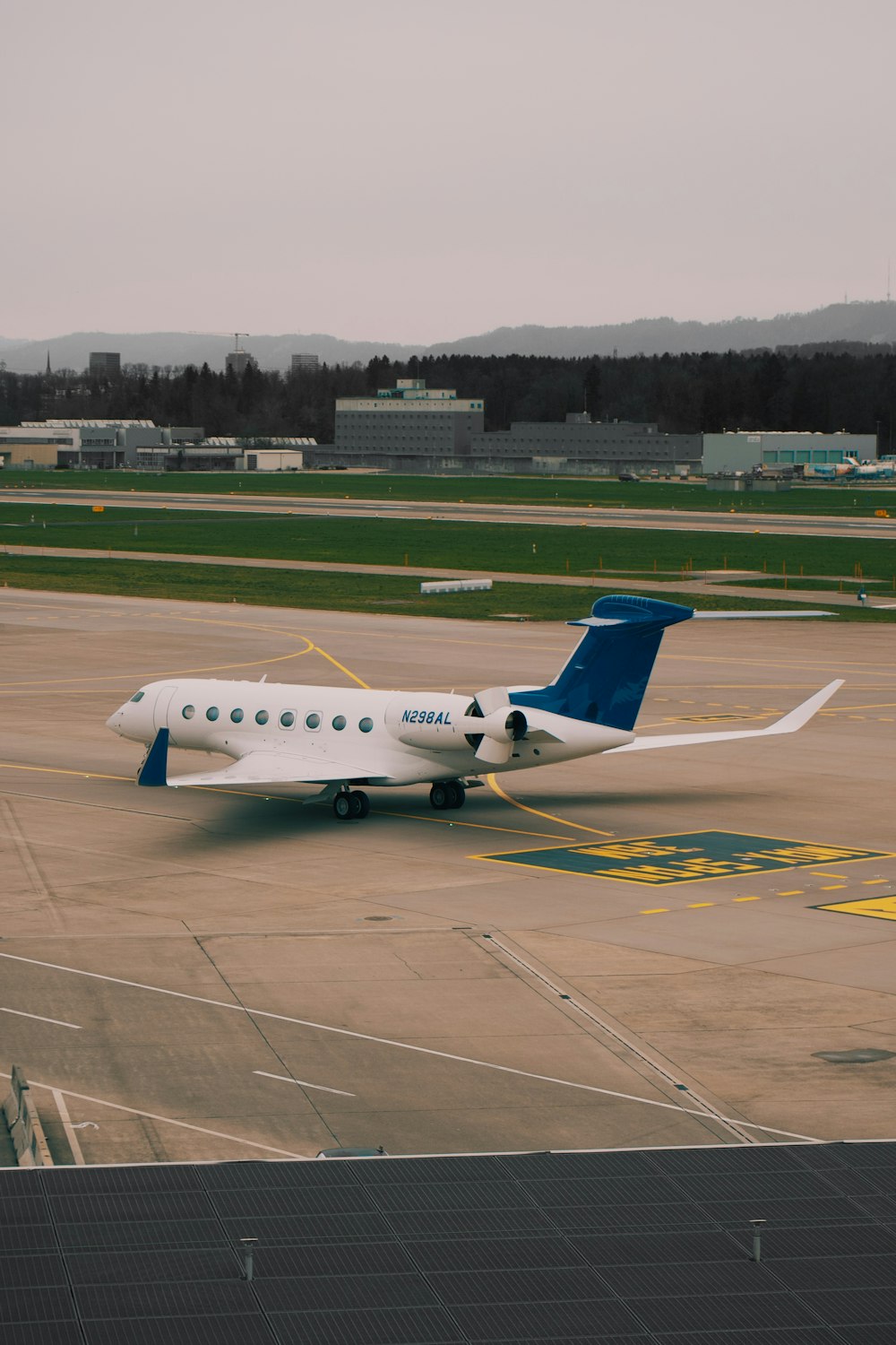 Un avión blanco y azul está en una pista