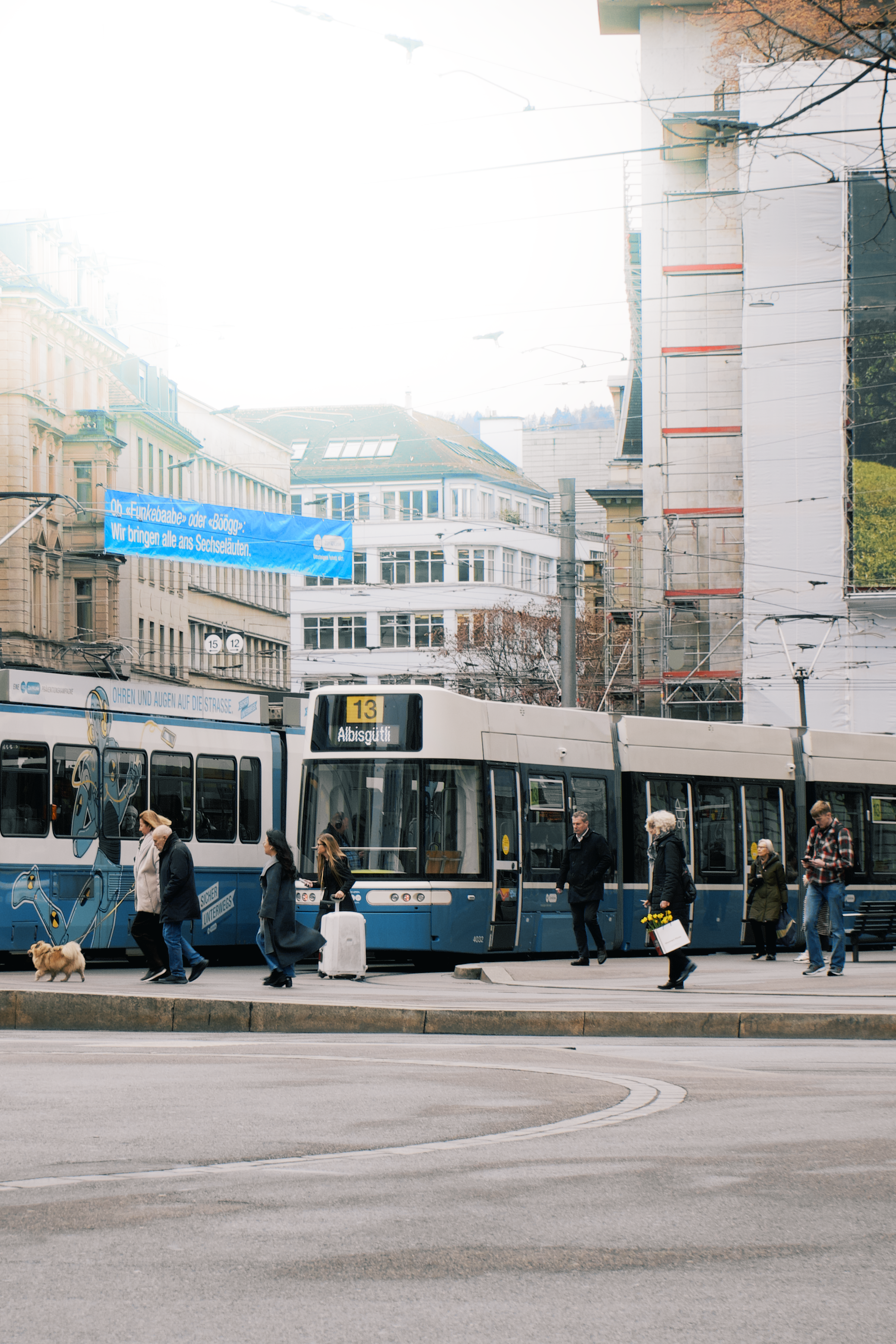 a group of people standing next to a blue and white train