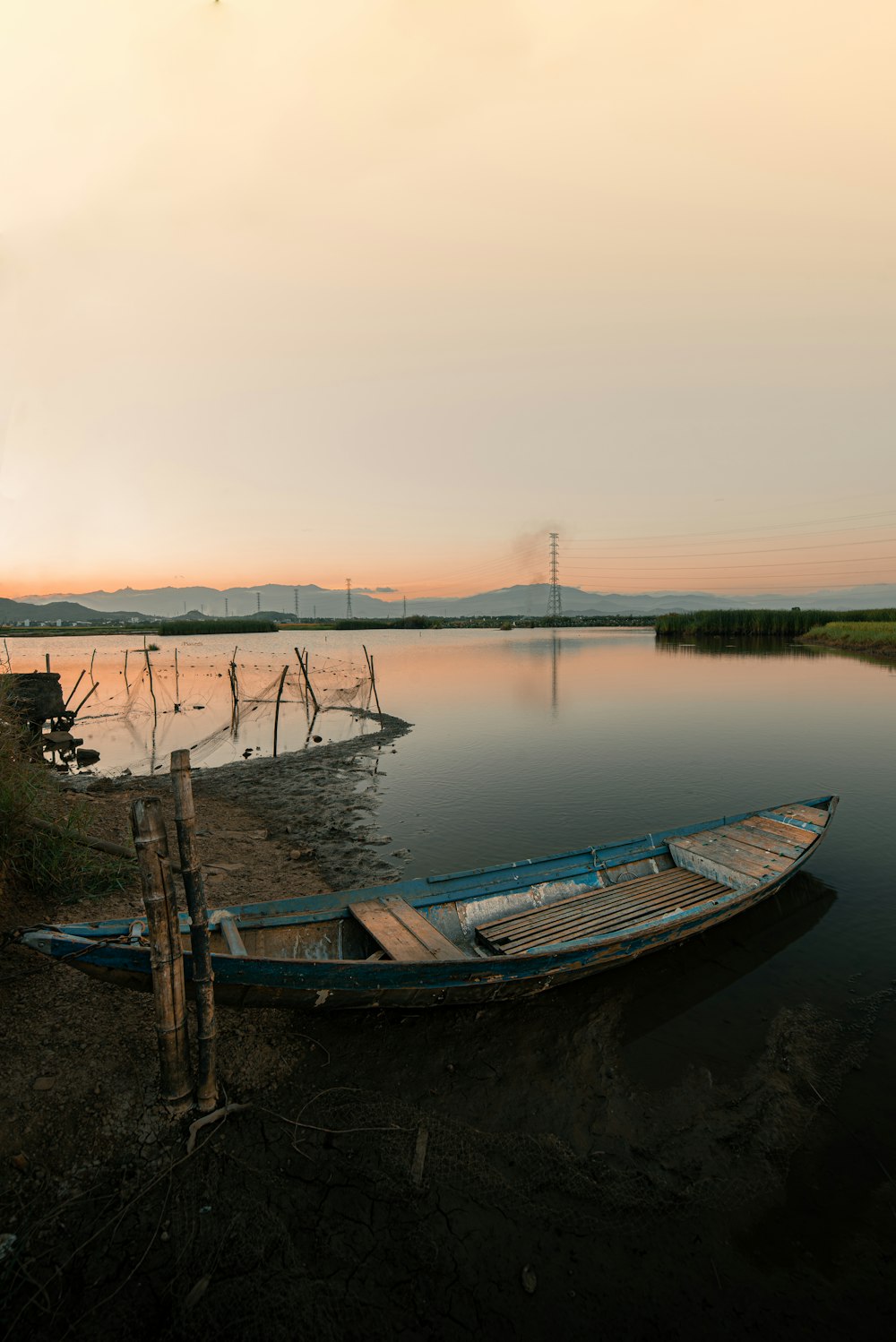 a boat sitting on the shore of a lake