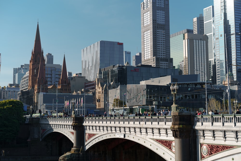 a bridge over a river with tall buildings in the background