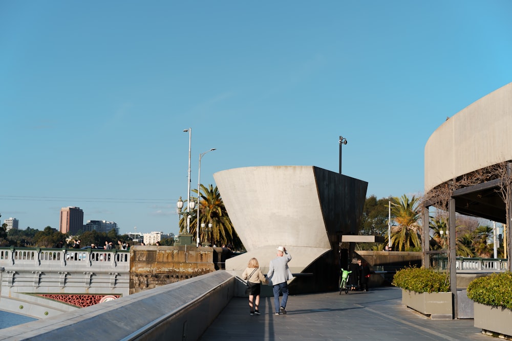 a couple of people walking across a bridge