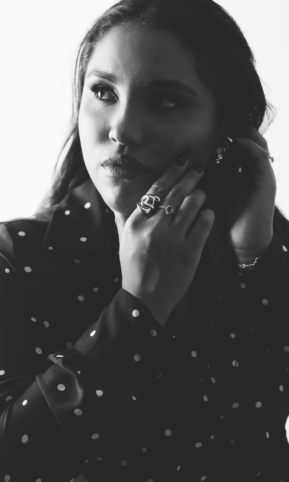 a black and white photo of a woman with a ring on her finger