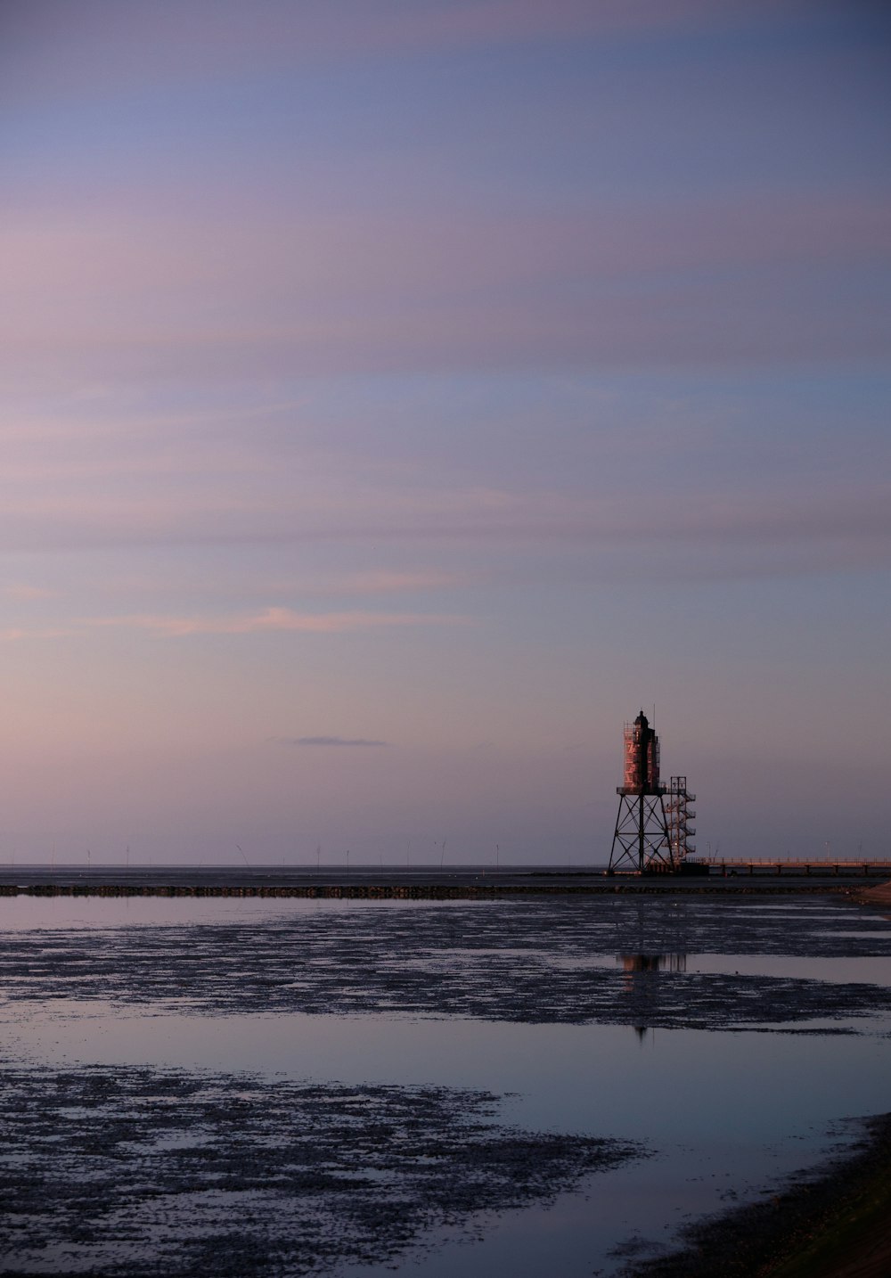 a large body of water with a tower in the background