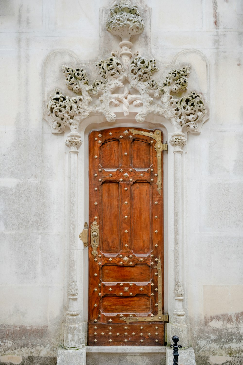 a large wooden door sitting in front of a white building