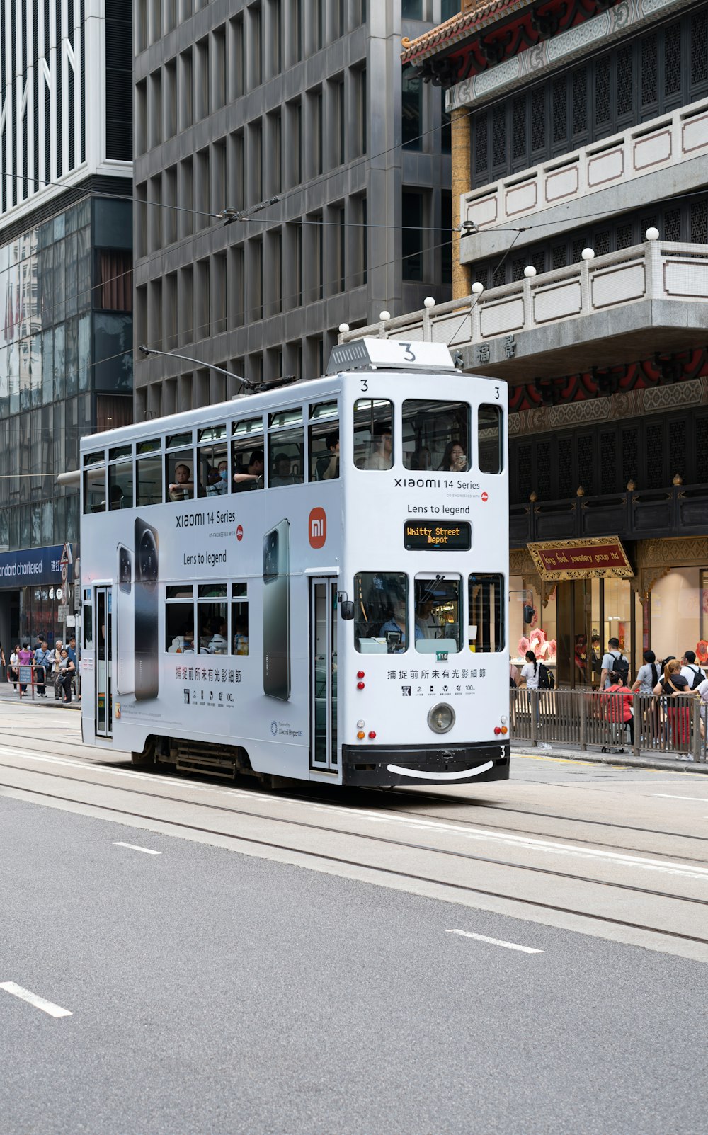 a white double decker bus driving down a street