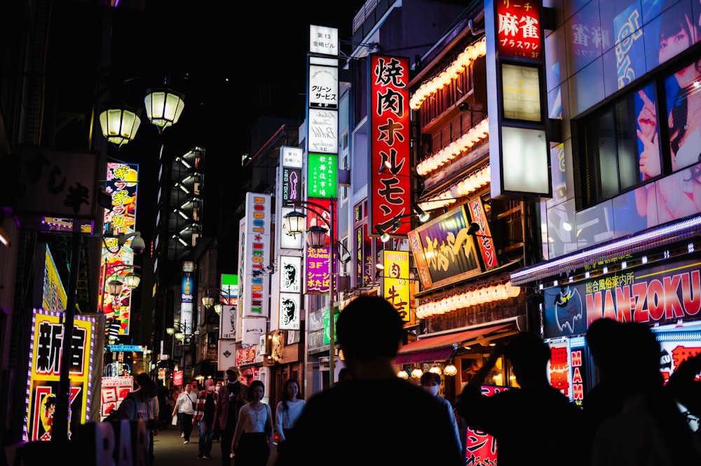 a group of people walking down a street at night