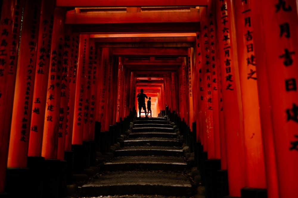 two people standing in a tunnel of red tori tori tori tori tori tori tori tori