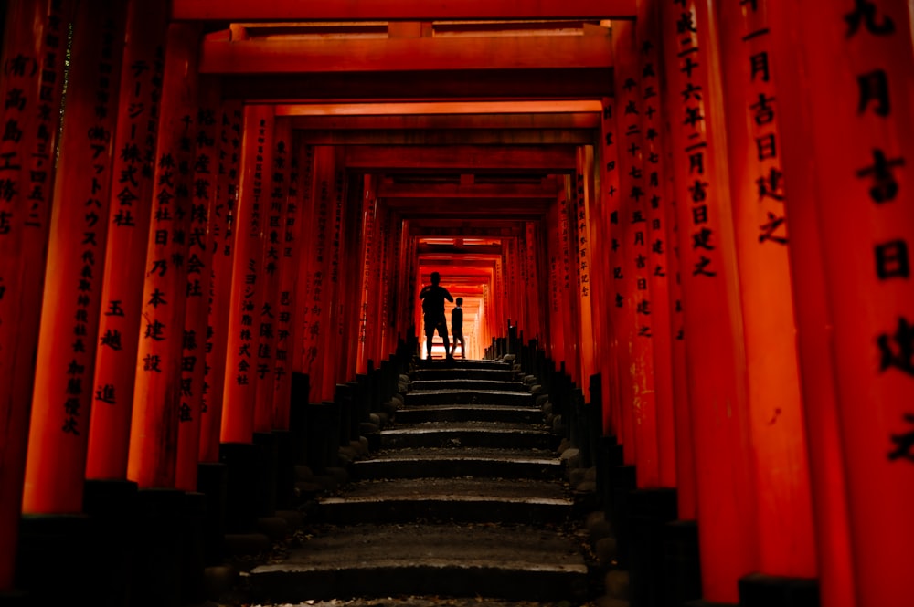 Dos personas de pie en un túnel de rojo tori tori tori tori tori tori tori tori