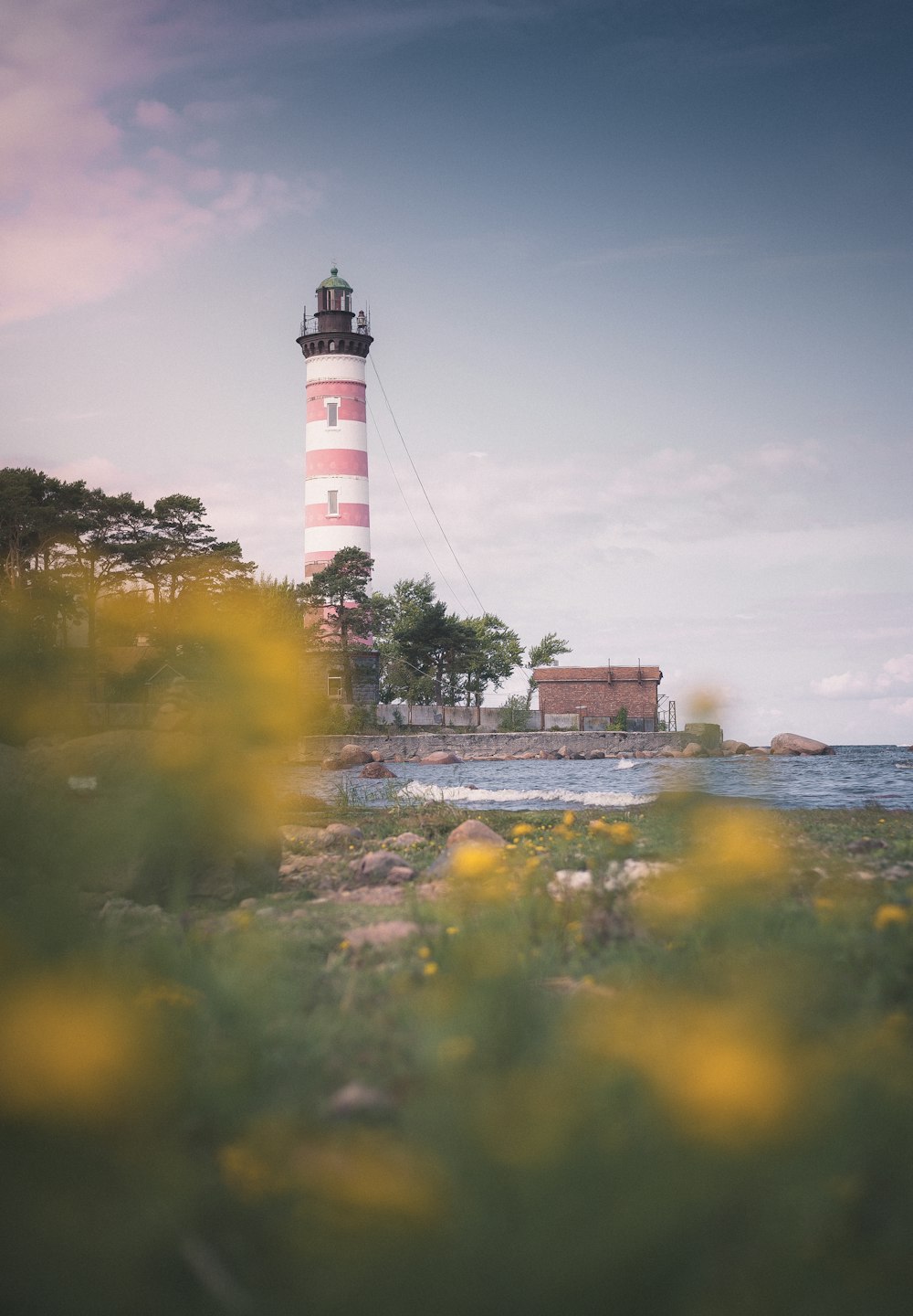 a light house sitting on top of a lush green field