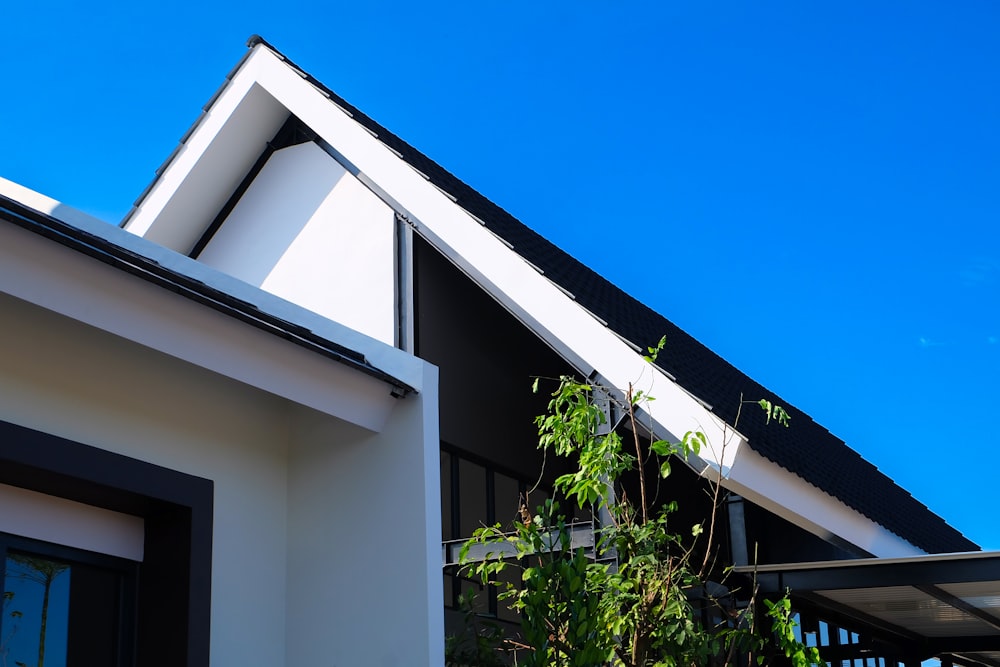 Una casa con techo negro y molduras blancas