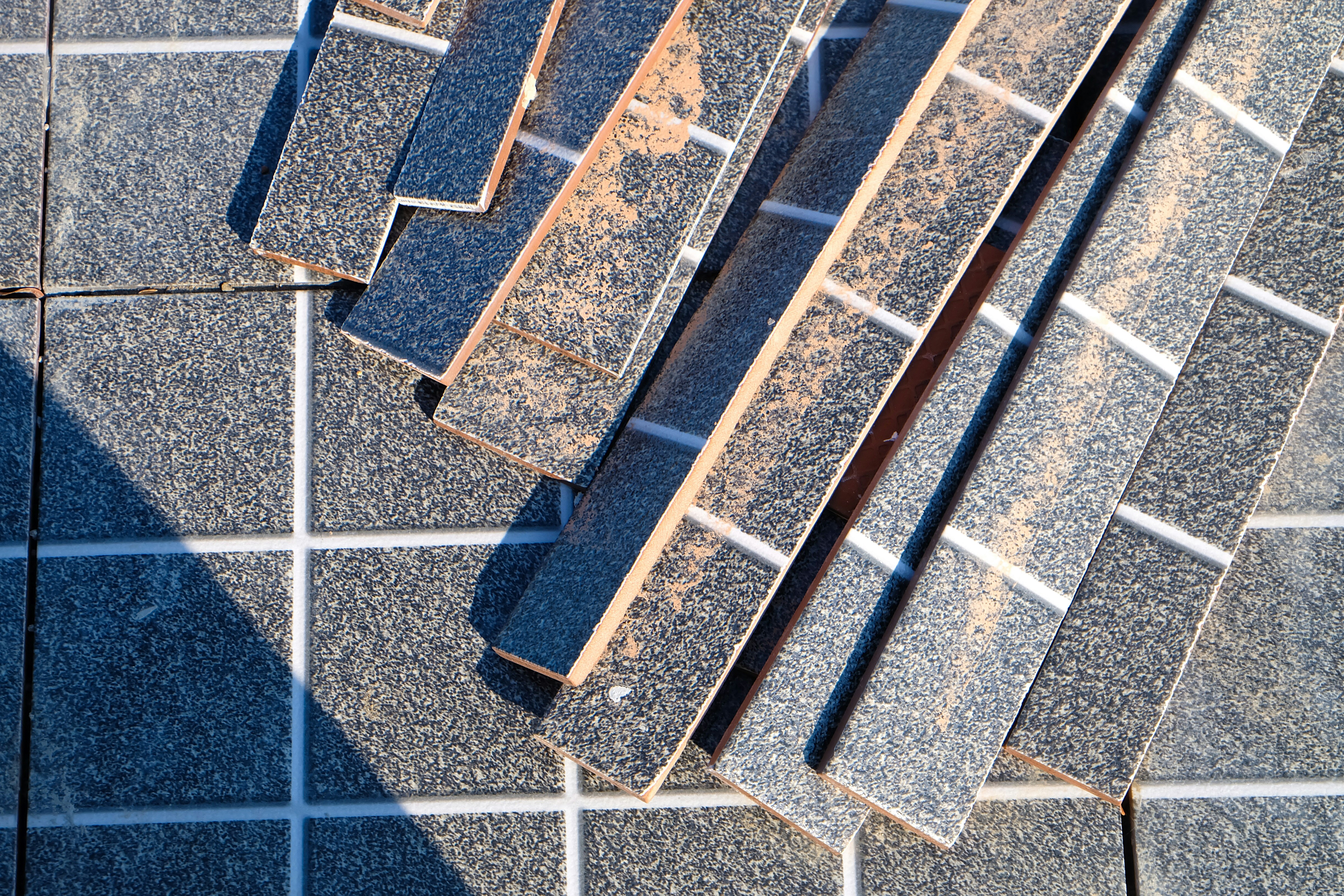 a close up of a tiled floor with a metal grate