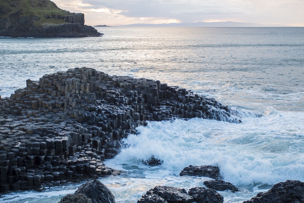 a rocky shore with waves crashing against the rocks