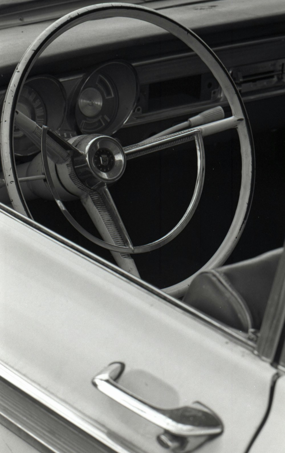a black and white photo of a car steering wheel