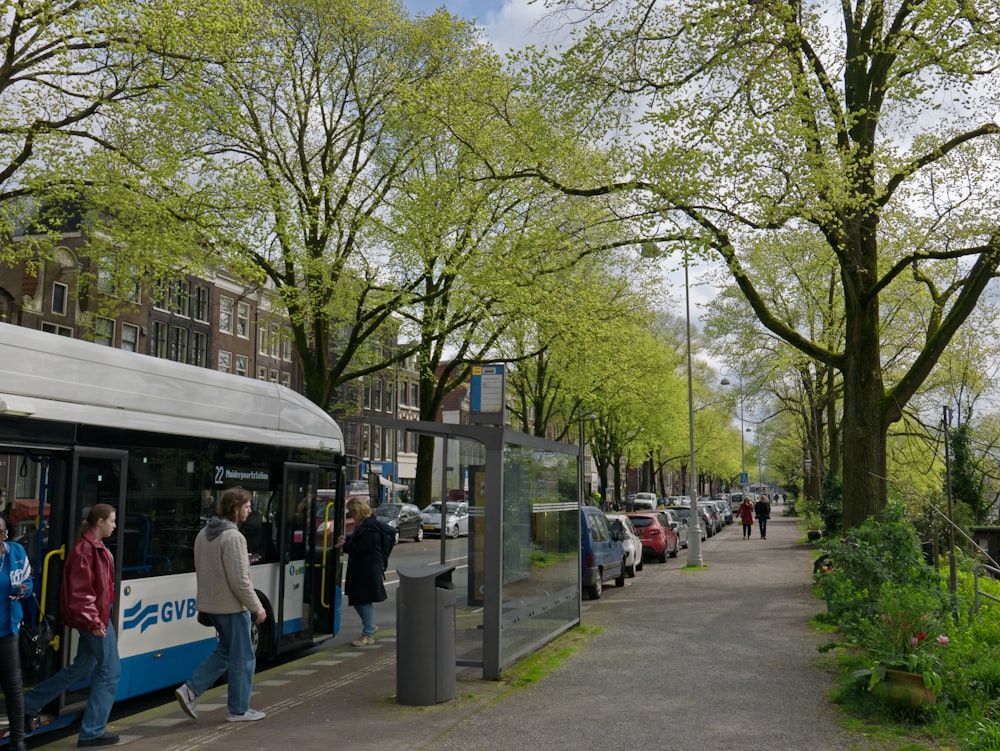 Eine Gruppe von Menschen, die an einer Bushaltestelle in einen Bus einsteigen