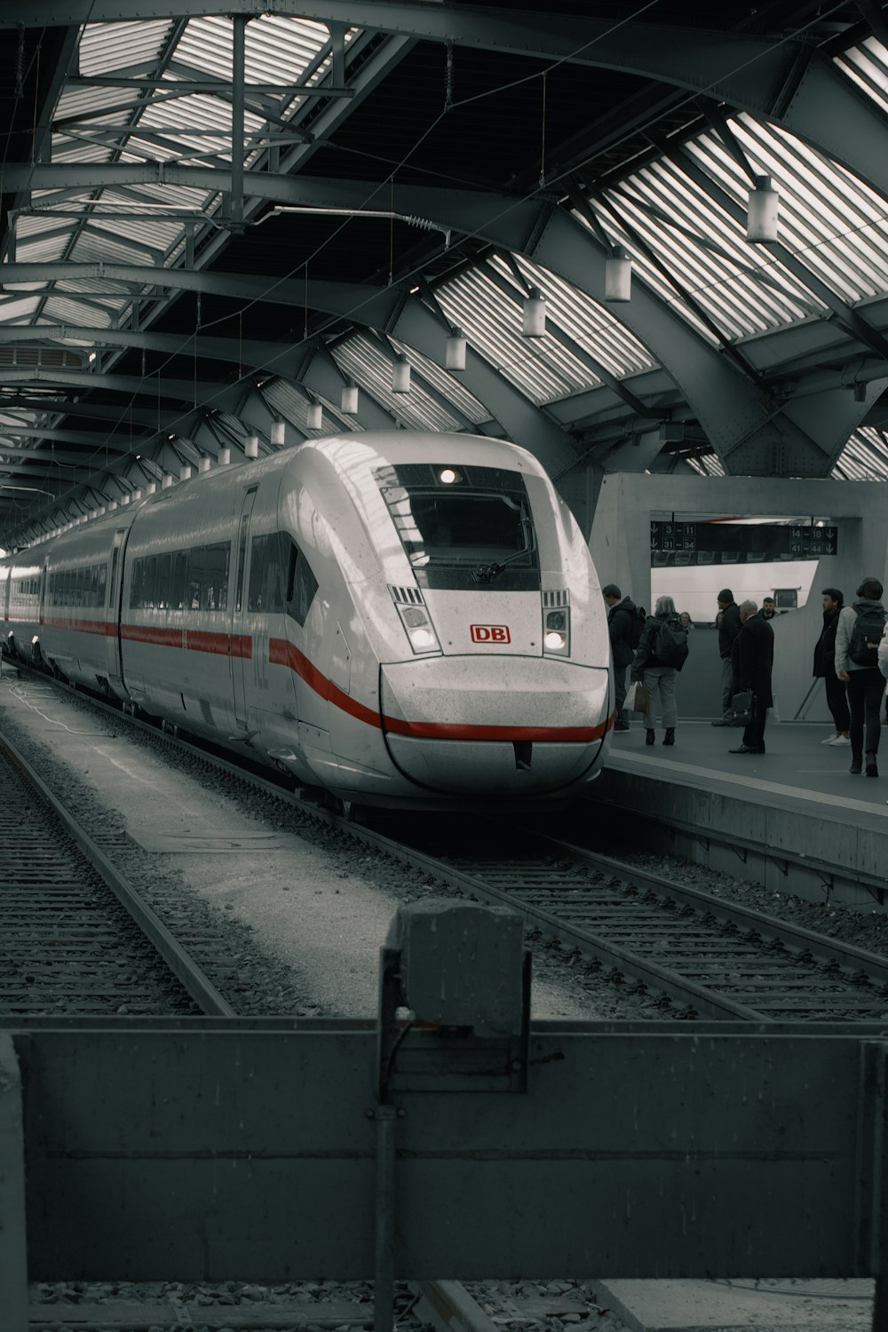 Un tren blanco y rojo que se detiene en una estación de tren