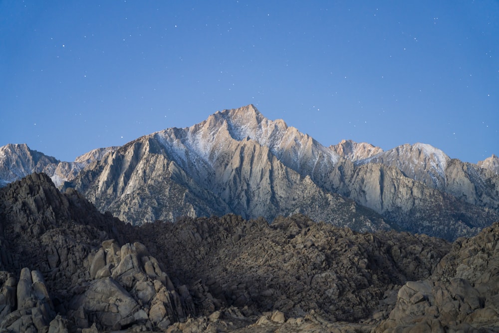 a view of a mountain range with stars in the sky