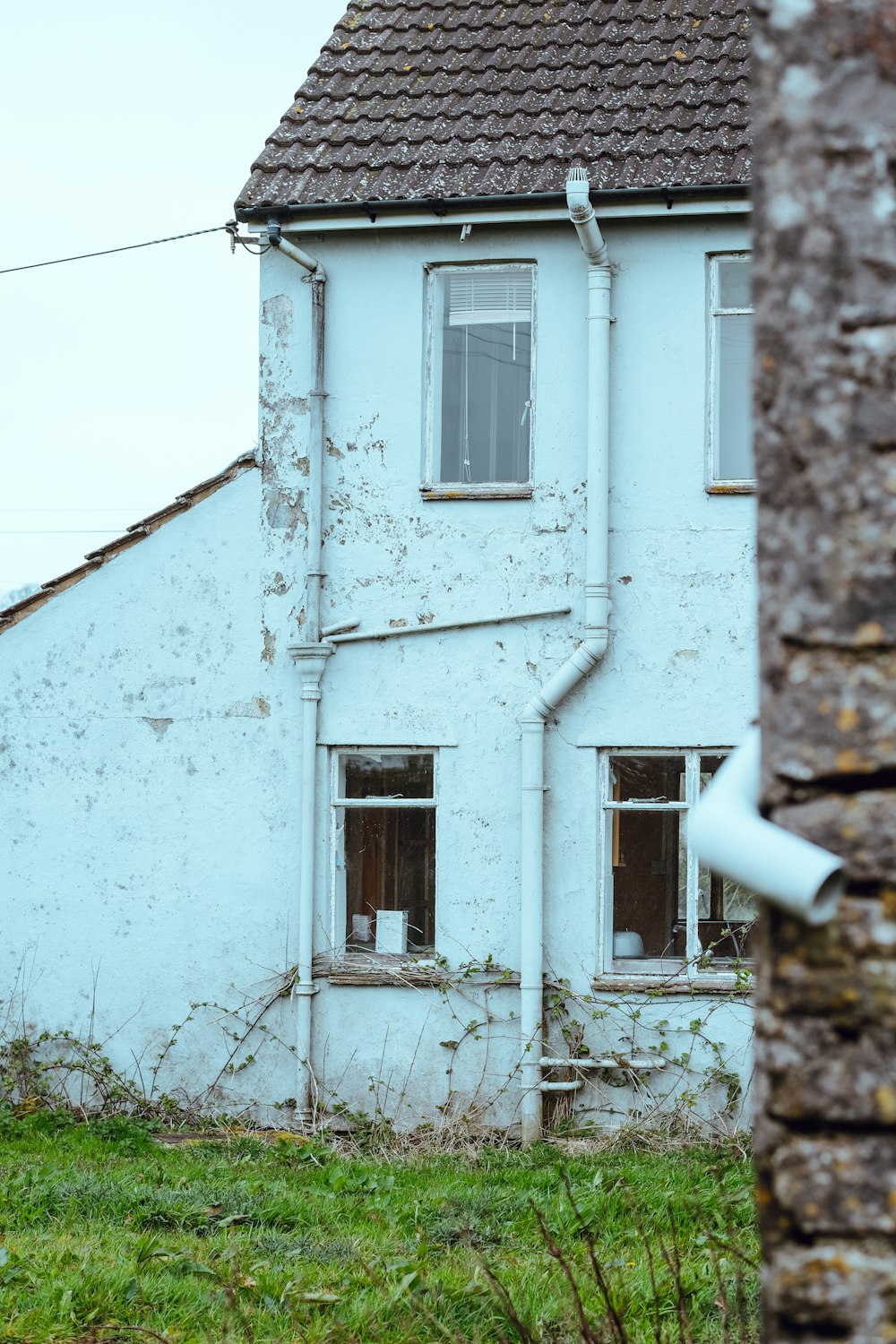 an old white house with a broken window