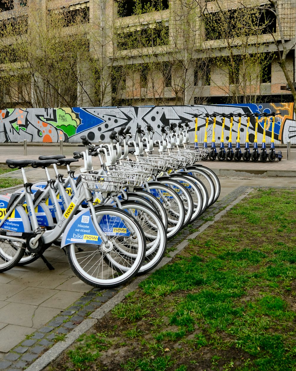 a row of bikes parked next to each other on a sidewalk