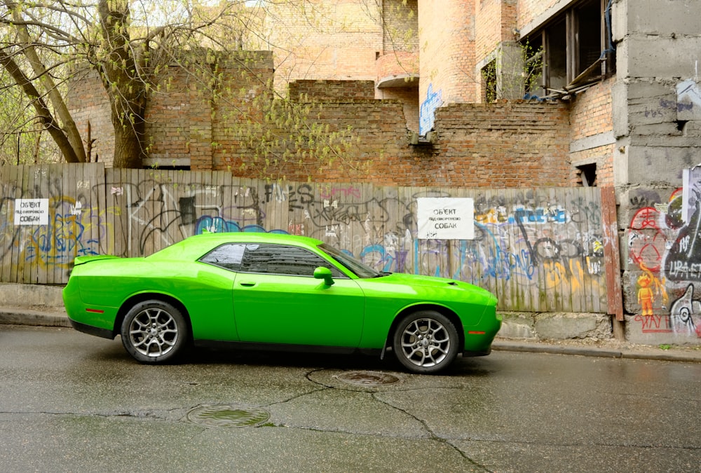 a green car parked on the side of the road