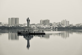 a statue of a person standing on top of a body of water