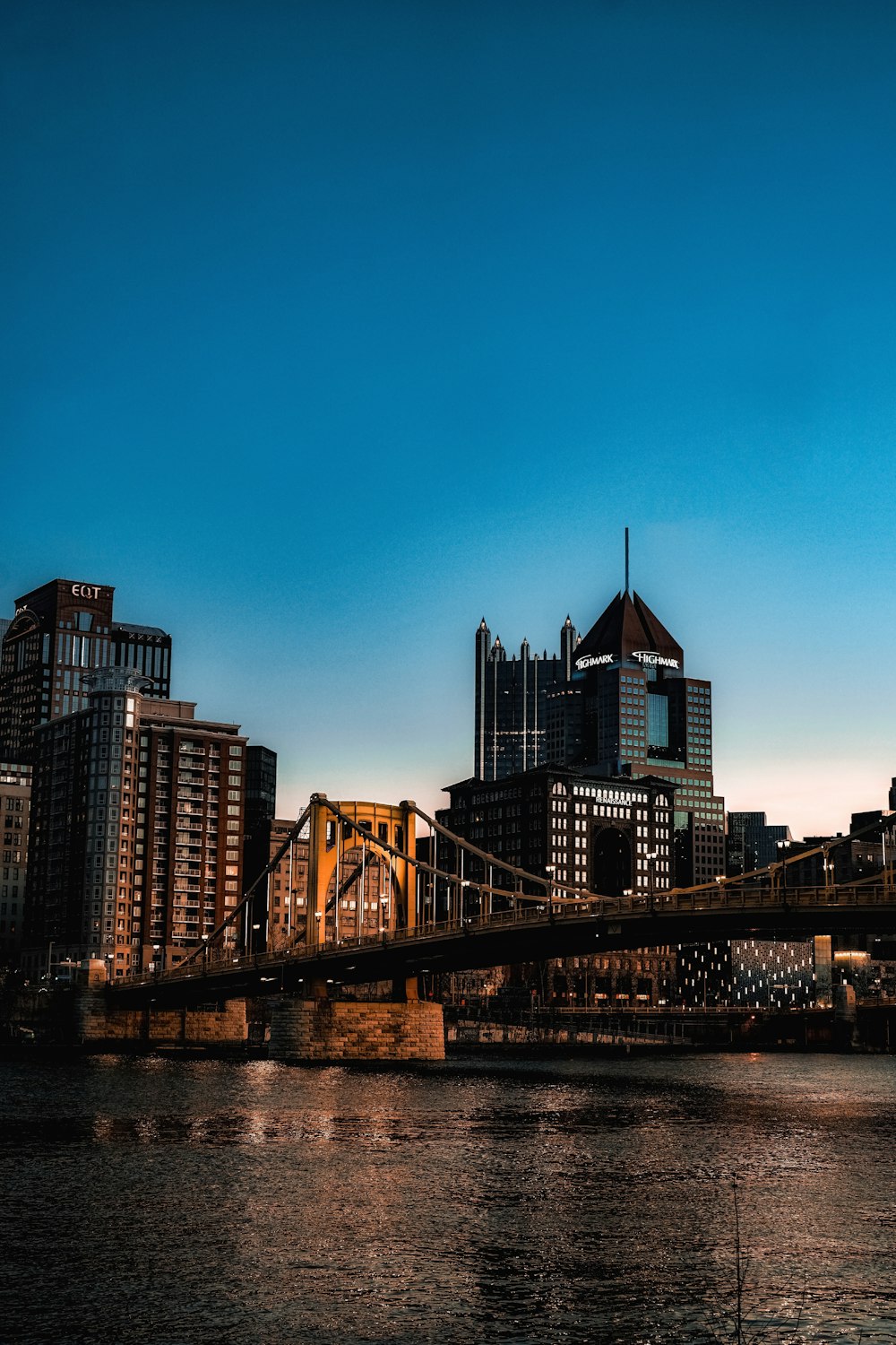 a bridge over a river with a city in the background