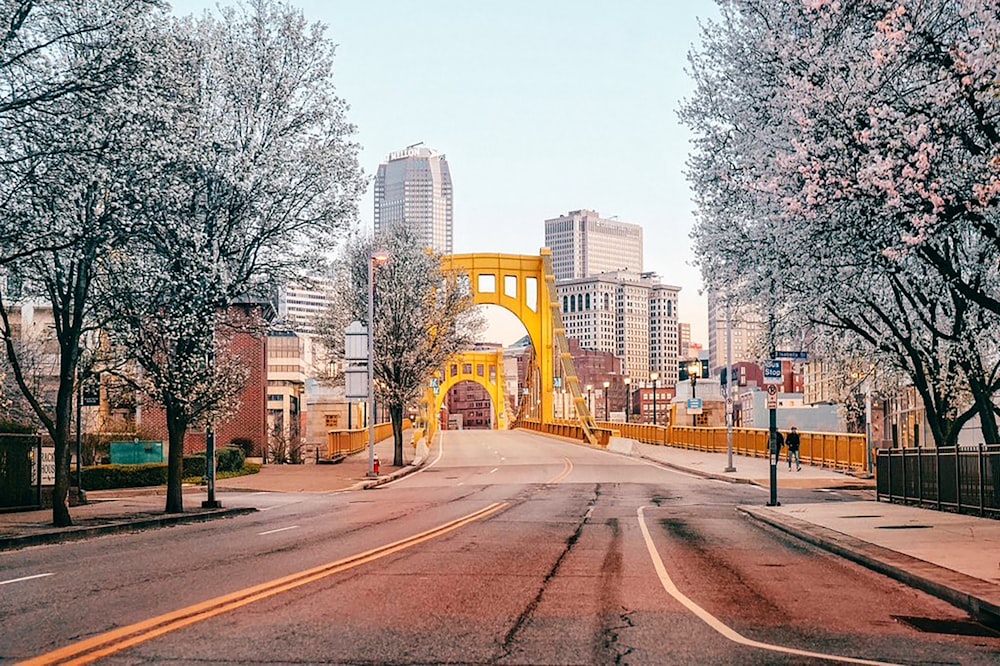 a yellow bridge over a street with tall buildings in the background
