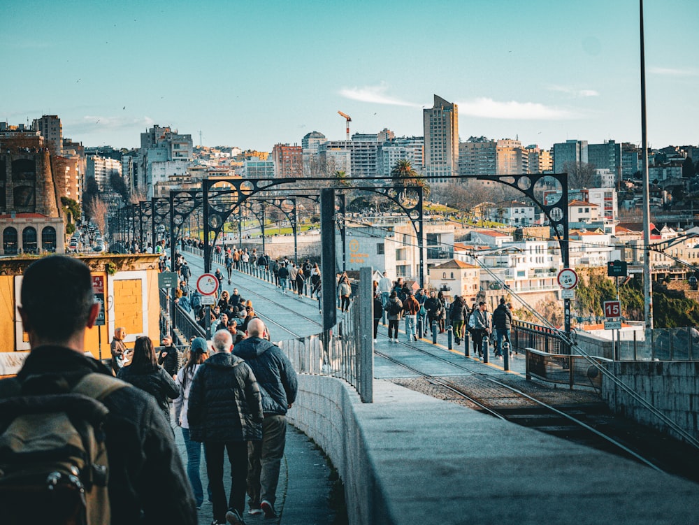 a group of people walking down a street next to a train